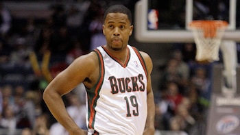 Un jugador de baloncesto viste una camiseta blanca con el número 19 y el nombre de los Bucks en una cancha durante un partido