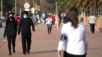 Gente con barbijo camina por