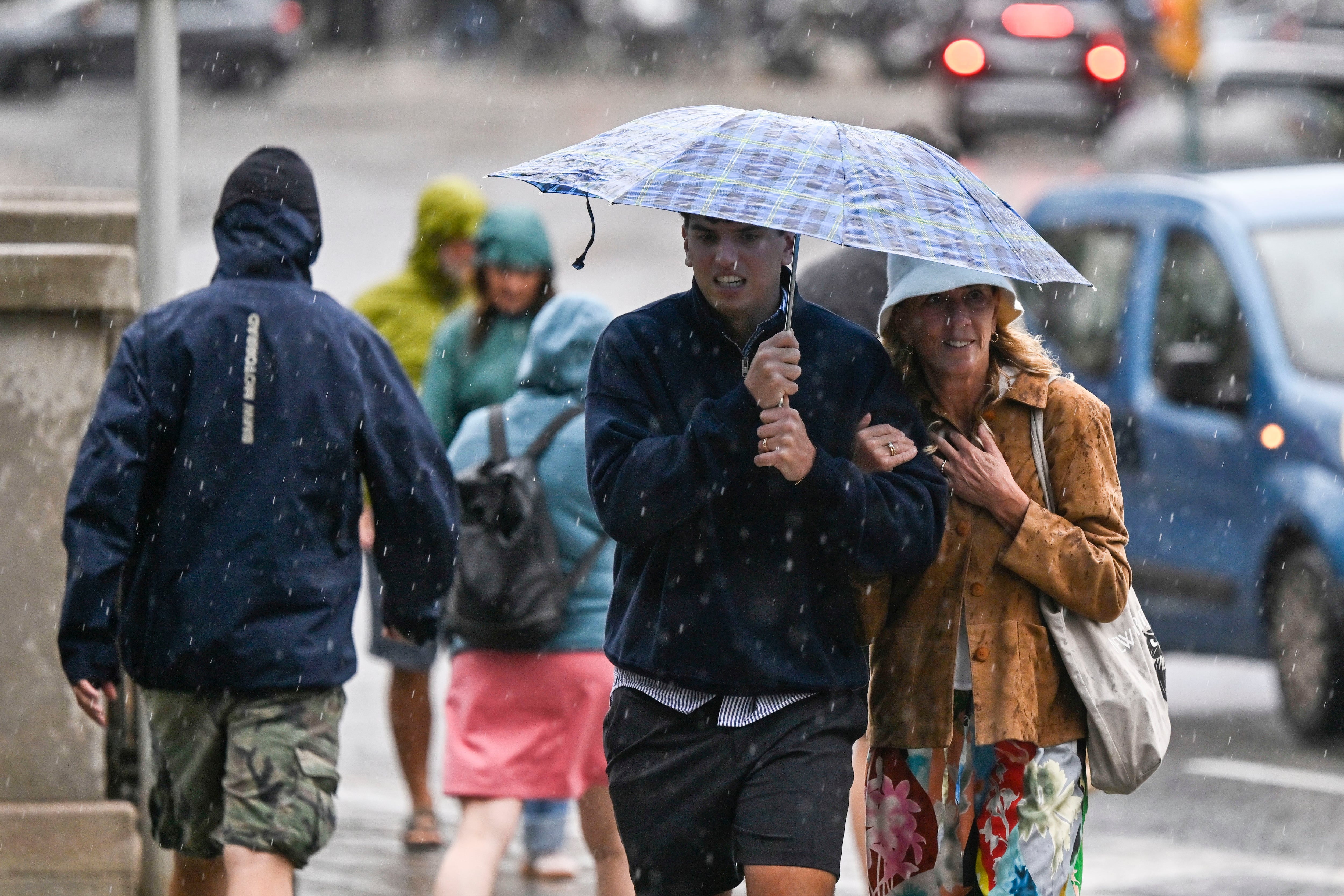 Varias personas se protegen de la lluvia en Palma. (Miquel A. Borràs/EFE)