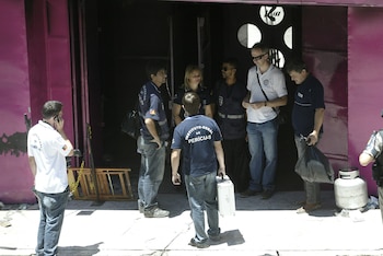 Fotografía fechada el 28 de enero de 2013 donde se ve a un grupo de policías forenses que se preparan para ingresar a la discoteca 'Kiss' tras un incendio. EFE/Neco Varella
