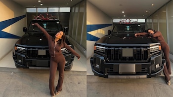 Valery Revello posa sonriente junto a una camioneta SUV negra nueva con un gran lazo rojo en el techo, dentro de un garaje