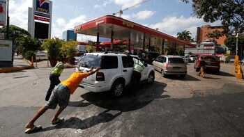 Unas personas empujan un automóvil