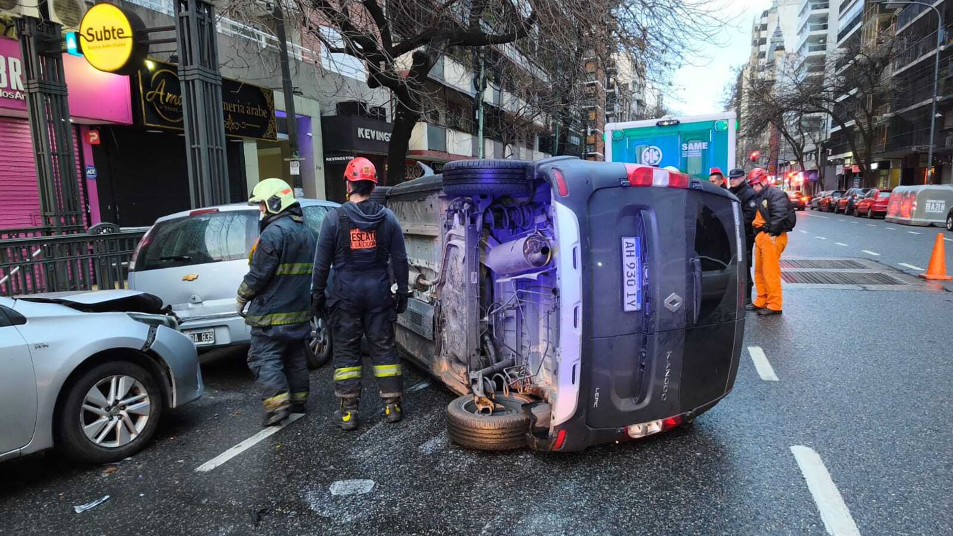 Personal de emergencia asiste en el lugar de un choque con un vehículo volcado y otros dos autos dañados en una calle del barrio de Almagro.