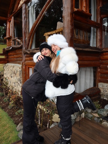 Julieta Poggio junto a una amiga, en la entrada de la cabaña donde se hospedaron en Bariloche