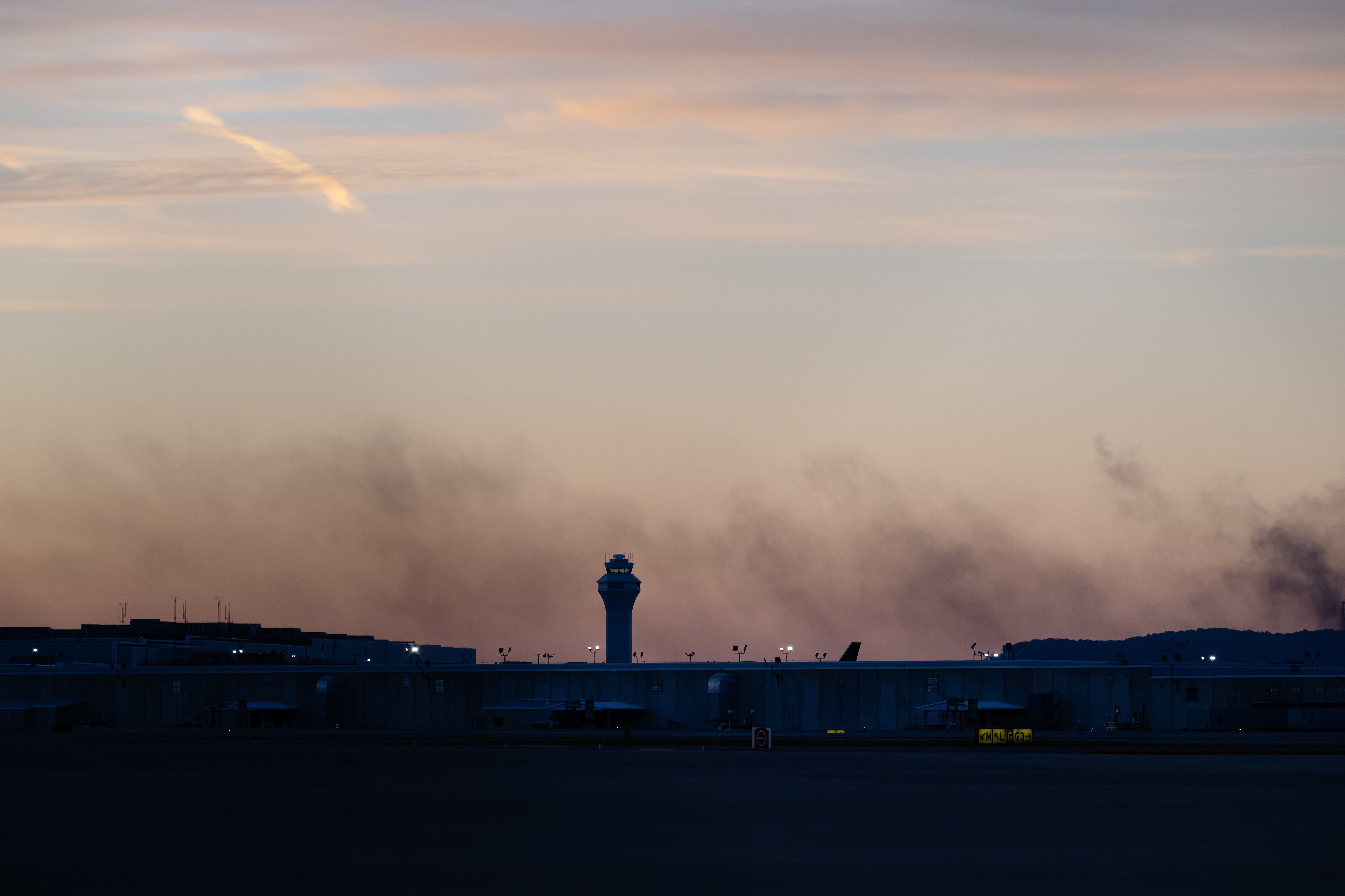 La torre de control se ve mientras sale humo del lugar donde se estrelló el vuelo 2976 de UPS cerca del Aeropuerto Internacional Louisville Muhammad Ali, el miércoles 5 de noviembre de 2025, en Louisville, Kentucky. (AP Foto/Jon Cherry)