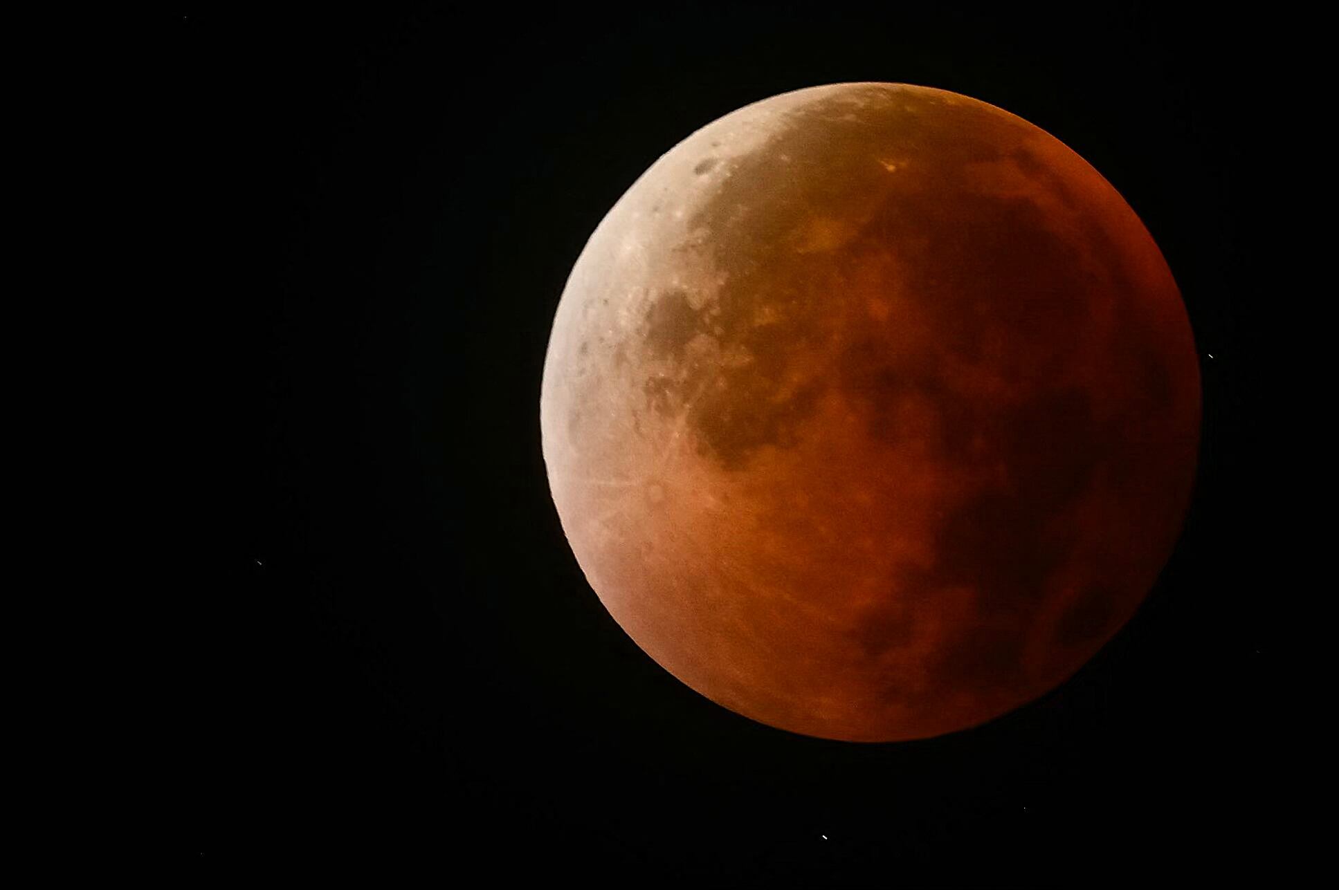 La sombra proyectada sobre la Luna adquiere tonalidad rojiza o anaranjada, el color depende de la dispersión de la luz en la atmósfera (Sai Aung MAIN / AFP)