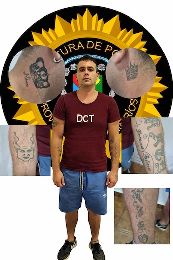 Retrato de un hombre de pie, con múltiples tatuajes visibles en el cuello, brazos y piernas, frente a un emblema de la Policía de Entre Ríos