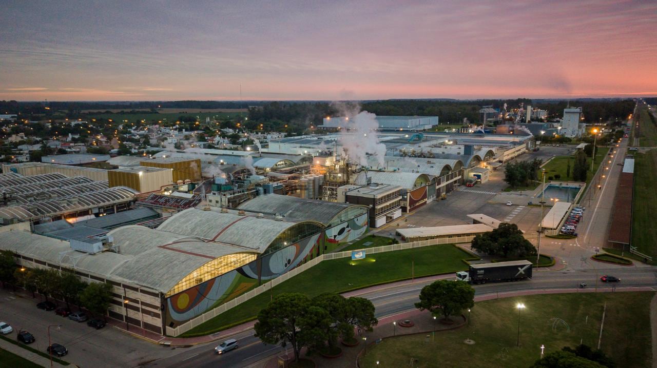 La planta de Grupo Arcor en Arroyito, una de las mayores fábricas de alimentos de Latinoamérica, opera intensamente al anochecer, destacando su rol crucial en la industria.