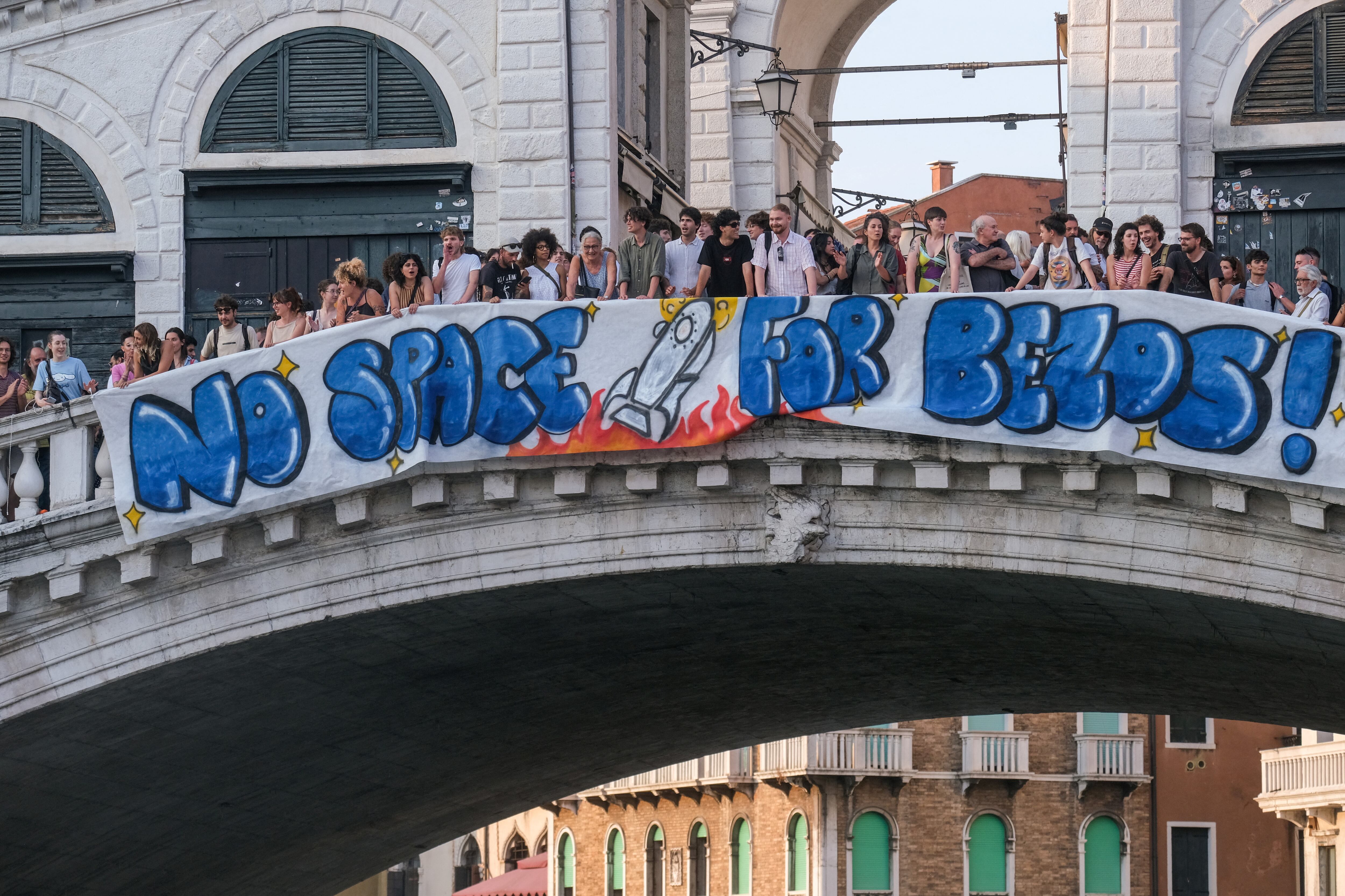 Protesters display a banner reading