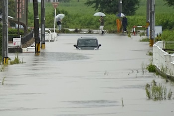 Un vehículo permanece en una calle inundada tras las fuertes lluvias en Himi, prefectura de Toyama, Japón, el jueves 27 de agosto de 2026 (Suo Takekuma/Kyodo News vía AP)