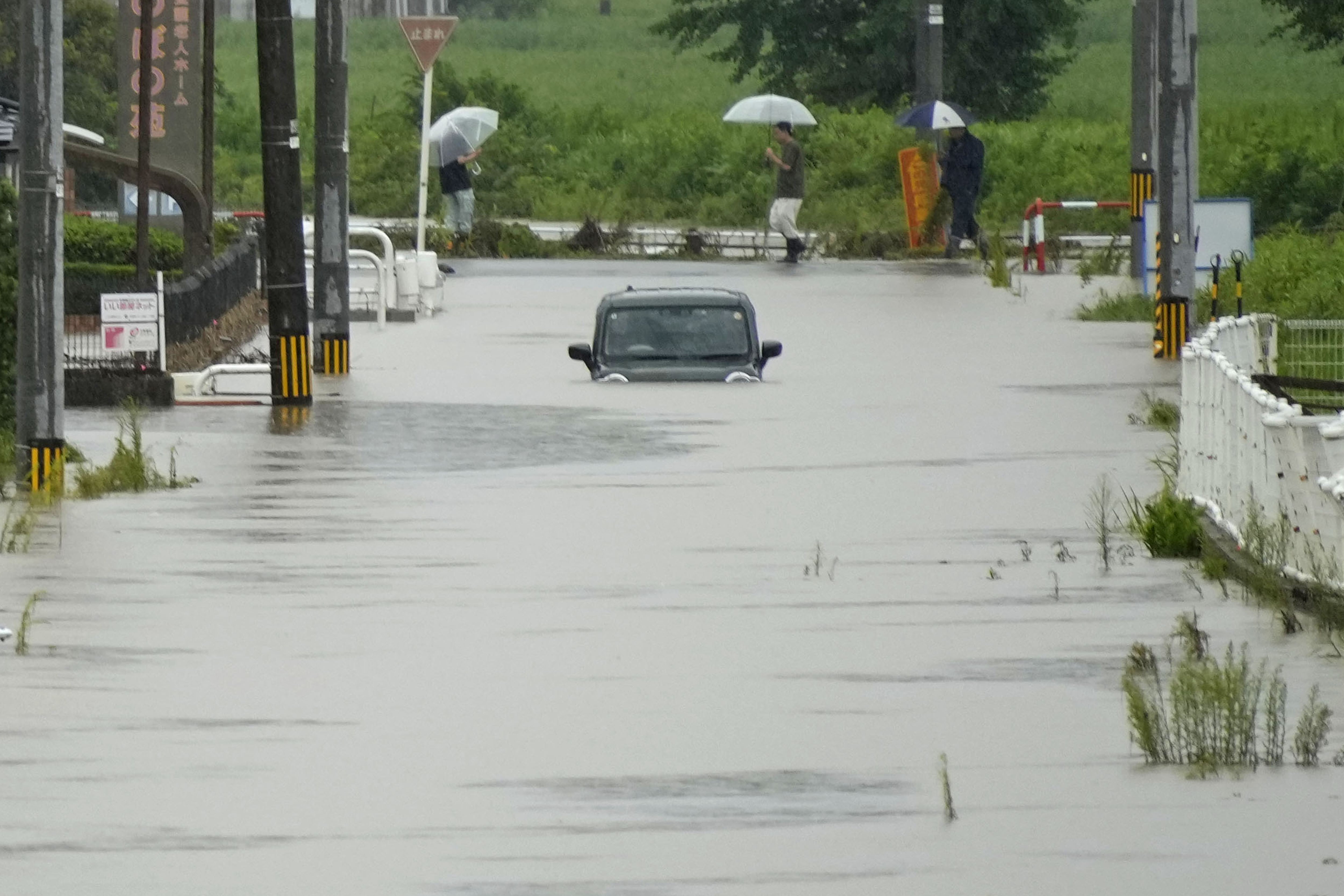 Un vehículo permanece en una calle inundada tras las fuertes lluvias en Himi, prefectura de Toyama, Japón, el jueves 27 de agosto de 2026 (Suo Takekuma/Kyodo News vía AP)