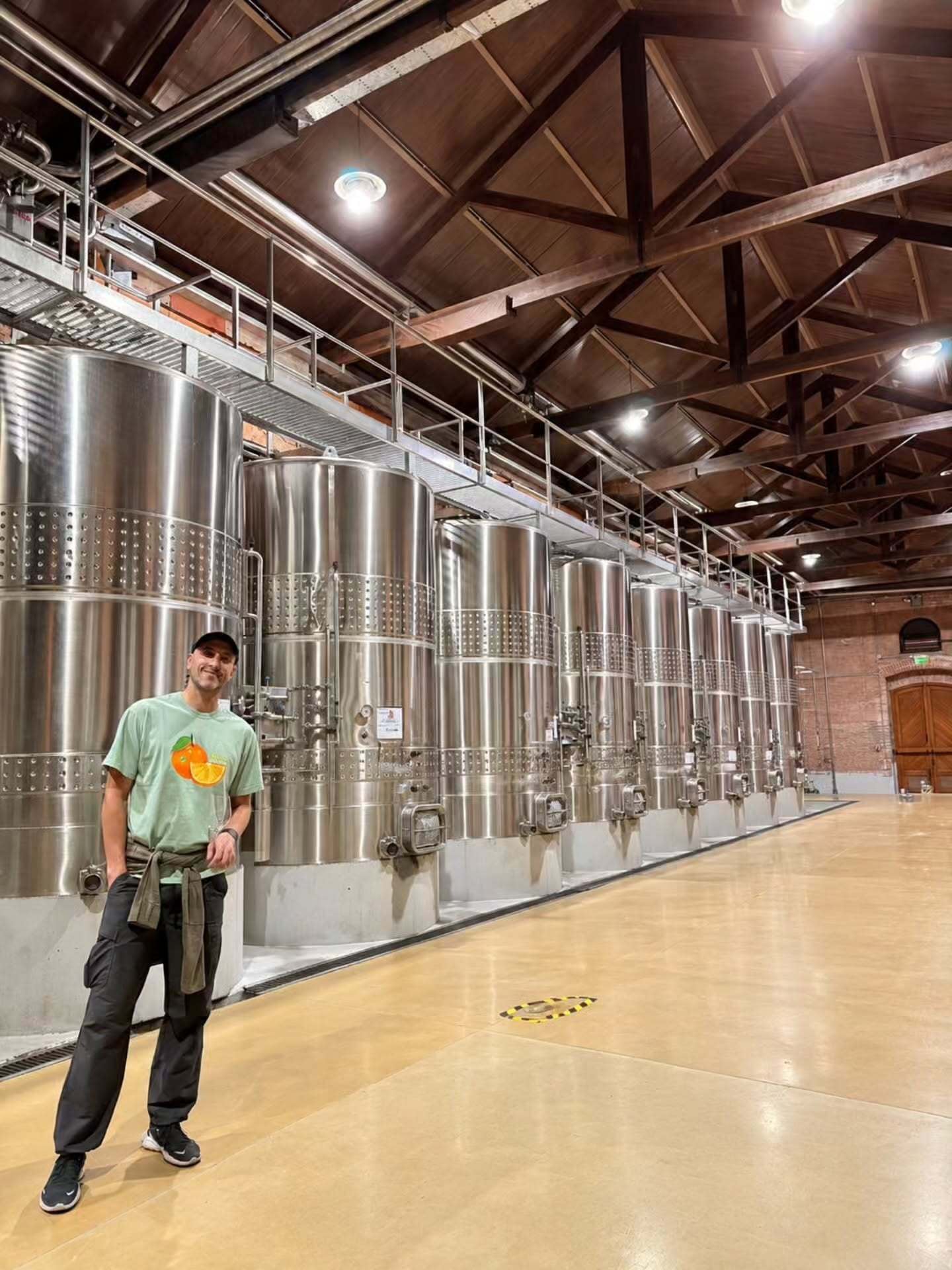 Manu Ginóbili posa junto a tanques de fermentación de acero inoxidable durante su visita a una bodega en la provincia de Mendoza.