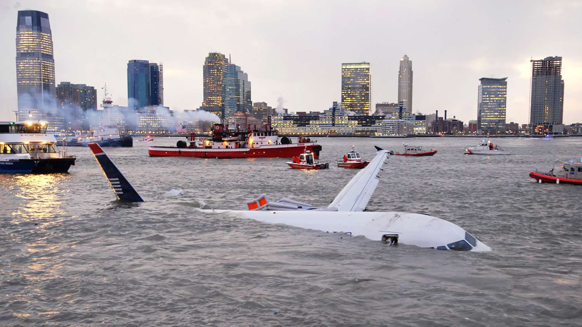 El Airbus A320 de US Airways flota parcialmente sumergido en el río Hudson, rodeado de embarcaciones de rescate
