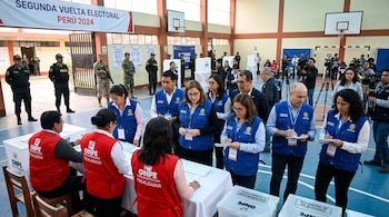 Centro de votación con personal de seguridad, observadores internacionales, fiscalizadores de ONPE y equipos de prensa presentes en Perú.