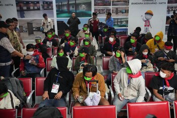 Trabajadores de centros de estafas en el este de Birmania esperan en una sala tras llegar desde Tailandia, en el Aeropuerto Internacional de Soekarno-Hatta en Tangerang, Indonesia, el viernes 28 de febrero de 2025 (AP Foto/Tatan Syuflana)