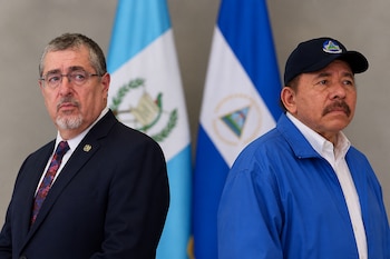 Bernardo Arévalo a la izquierda y Daniel Ortega a la derecha posan frente a las banderas de Guatemala y Nicaragua.