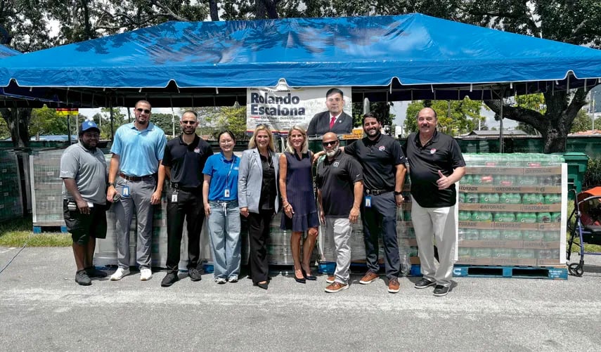 La comisionada de Miami-Dade, Vicki L. López, posa junto a trabajadores de los Marlins y los transportistas de ayuda a Venezuela este lunes en el estacionamiento del estadio loanDepot Park en Miami, Florida (EFE)