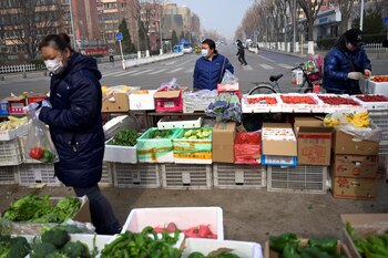 Residentes con máscaras faciales compran