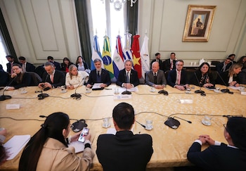 Funcionarios sentados a una gran mesa frente a las banderas de Argentina, Brasil, Paraguay, Uruguay, Vietnam y el Mercosur