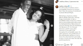 Fotografía en blanco y negro de Michael Wright sonriendo y bailando junto a una mujer vestida de blanco, al lado de un texto en inglés