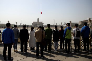 Personas guardan silencio frente a la bandera china