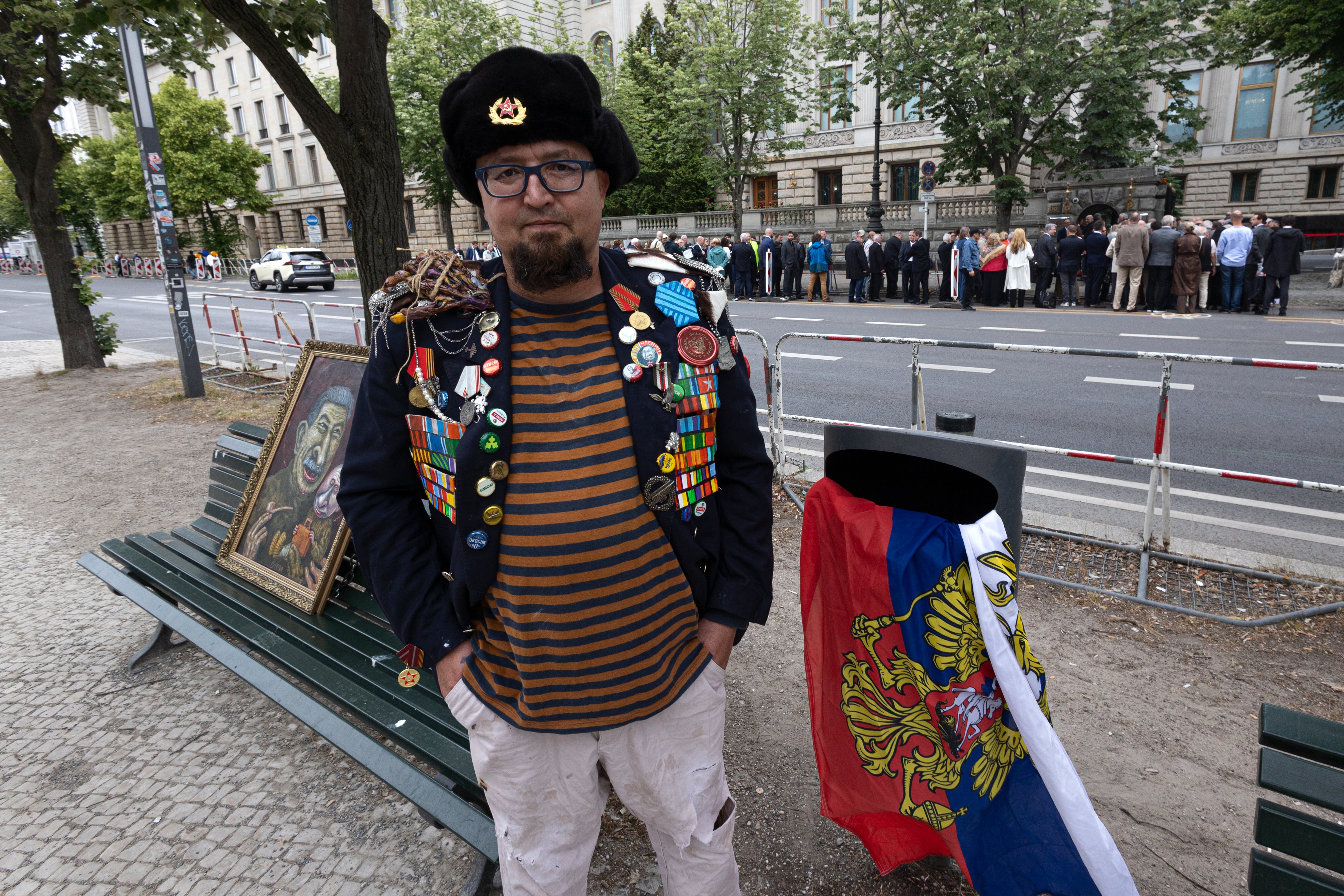 Un hombre identificado por medios polacos como Robert Kuzovkov y por la fiscalía como Robert K., de acuerdo con las leyes polacas de privacidad, que según dijeron era un artista con el pseudónimo Semyon Skrepetsky, posa para una foto con una de sus obras junto a la embajada rusa en Berlín, Alemania, el viernes 12 de junio de 2026, cuatro días antes de morir baleado en Biala Podlaska, Polonia, según autoridades polacas. (Vasily Krestyaninov/SOTA via AP)
