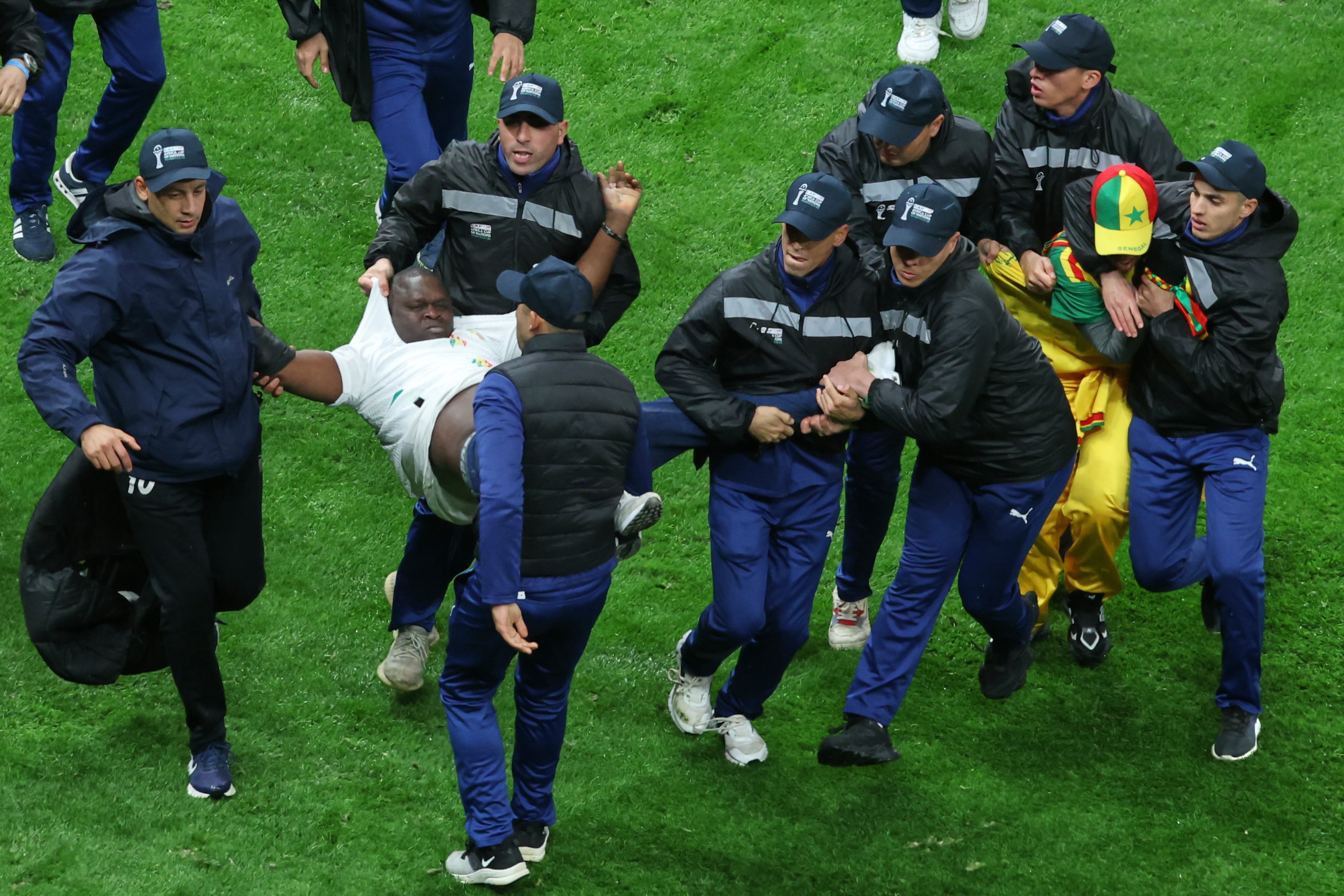 Hinchas de Senegal son retirados de la cancha durante la final de la Copa Africana de Naciones (AP Foto/Youssef Loulidi)