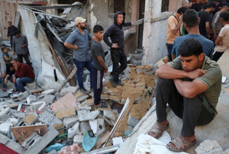 Un hombre sentado junto a un grupo reunido en el lugar de un ataque israelí contra una casa en Jabalia, en el norte de la Franja de Gaza. 23 de mayo de 2025 (REUTERS/Mahmoud Issa)
