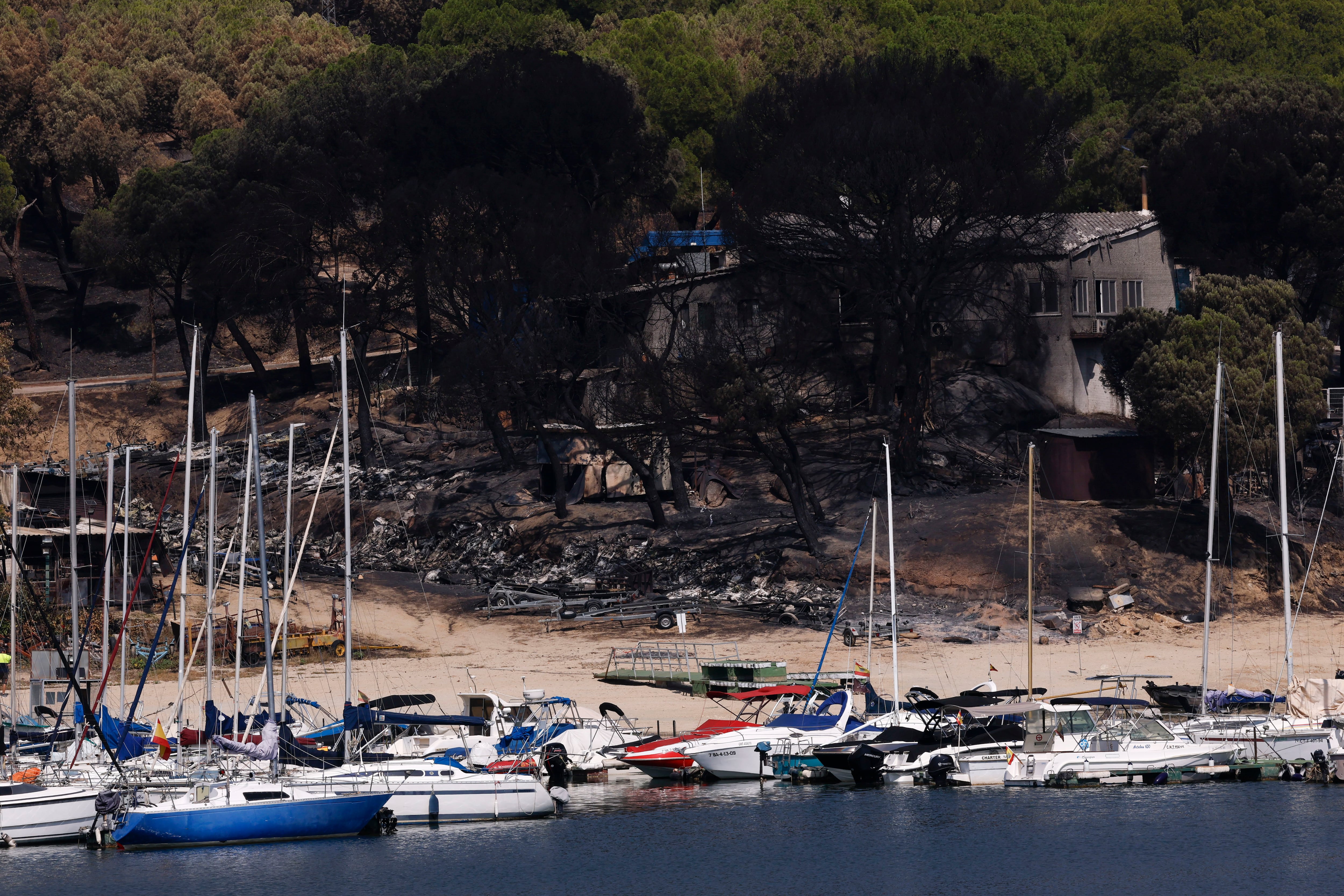 Vista de la fila de las lanchas motoras carbonizadas este jueves en el Pantano de San Juan tras el incendio que asoló la región. (EFE/Chema Moya)