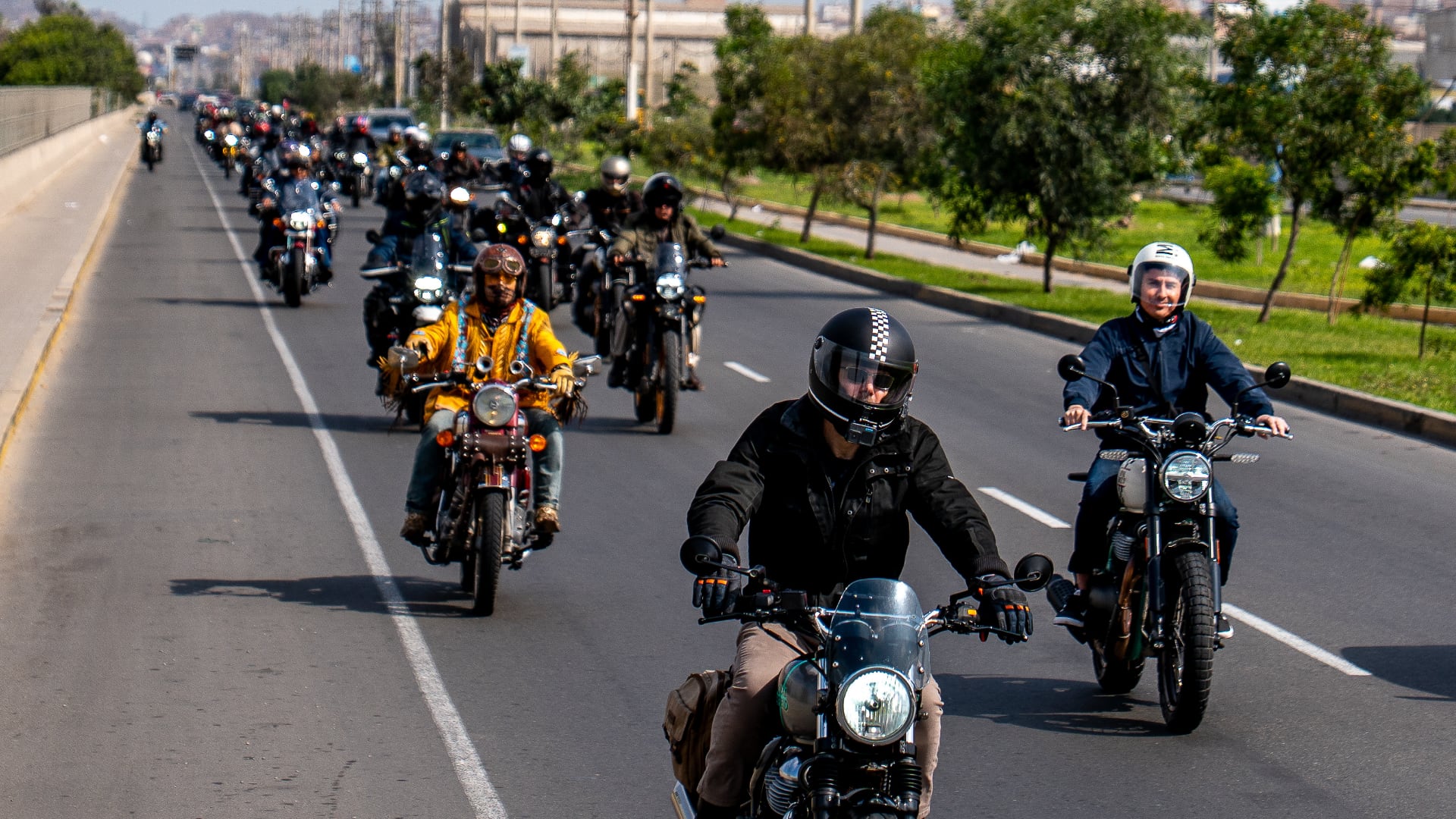 Un grupo de motociclistas avanza en caravana por una autopista de Lima durante la jornada global de rodada impulsada por Royal Enfield.