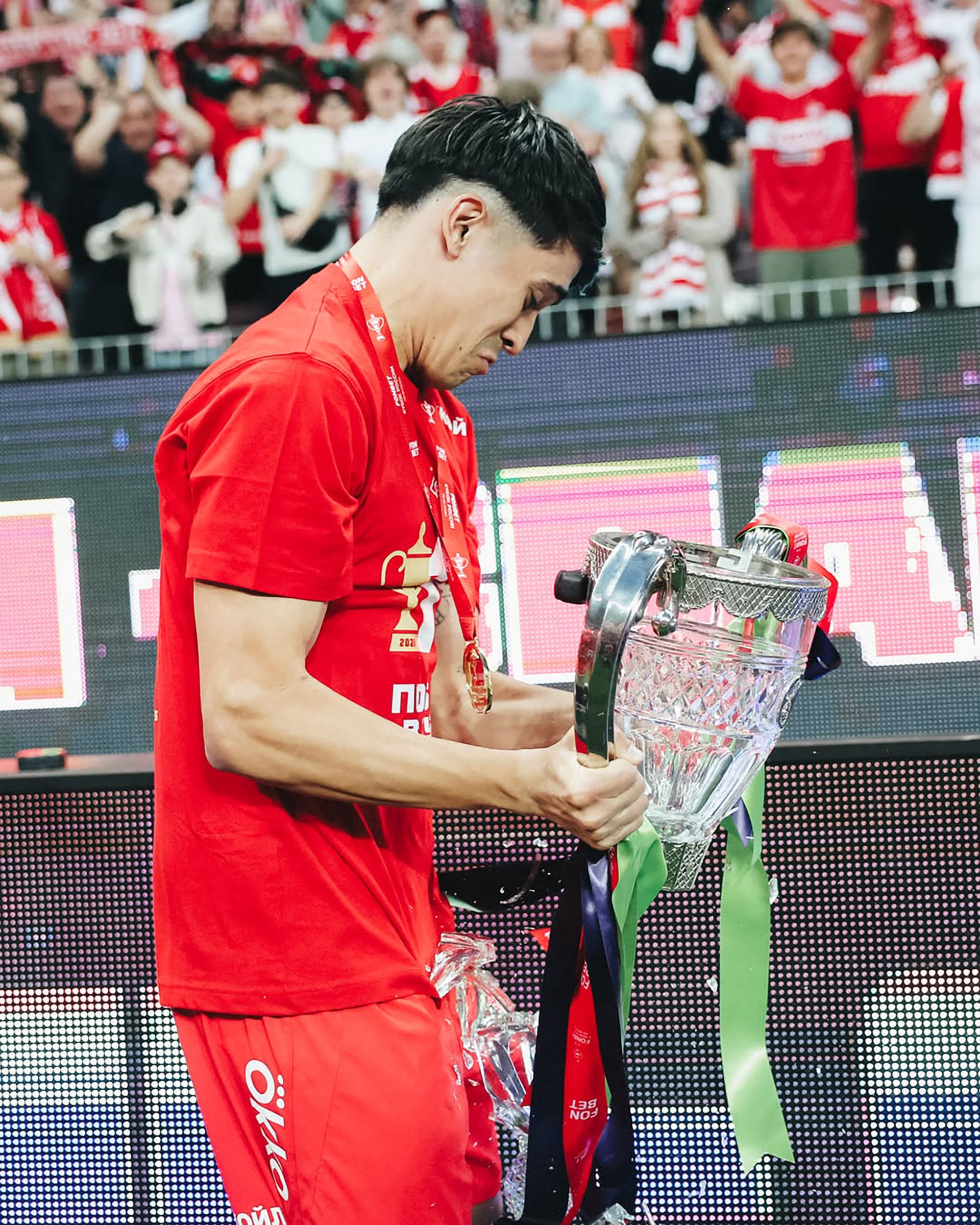 Pablo Solari sostiene el trofeo de cristal roto visiblemente afectado tras un incidente durante las celebraciones del campeonato.