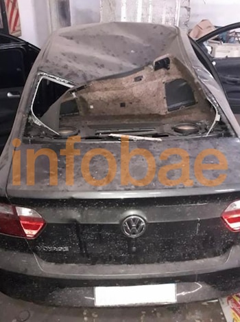 Parte trasera de un Volkswagen Voyage gris oscuro con el techo gravemente abollado y la luneta trasera completamente destrozada, mostrando el interior del vehículo