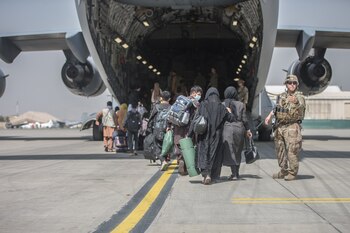 Decenas de familias suben a un avión de transporte C-17 Globemaster III de la Fuerza Aérea de Estados Unidos durante una evacuación en el aeropuerto internacional Hamid Karzai, Afganistán (U.S. Marine Corps/Sgt. Samuel Ruiz/Handout via REUTERS)