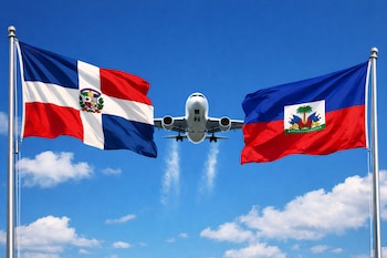 Un avión blanco en vuelo, con tren de aterrizaje, entre las banderas de República Dominicana (izquierda) y Haití (derecha), bajo un cielo azul con nubes.