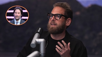 Jonah Hill con barba y gafas, hablando por un micrófono de Apple Music. En la esquina superior izquierda, una imagen circular de Keanu Reeves en traje