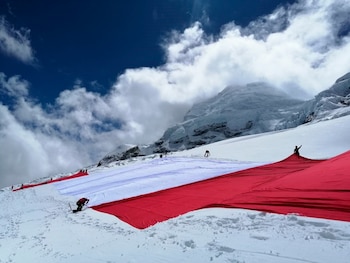 AME4005. LIMA (PERÚ), 21/07/2021.- Fotografía fechada el 11 de julio de 2021, cedida por Expedición "Bandera del Bicentenario", que muestra una bandera peruana gigante en la montaña de Huascarán (Perú). Una bandera peruana gigante de 4.000 metros cuadrados lució sus colores rojo y blanco sobre el Huascarán, la montaña más alta de Perú, para conmemorar el bicentenario de la independencia del país, que se celebrará este 28 julio.Con 200 metros de largo, 20 de ancho y un peso de más de 300 kilos, el enorme símbolo nacional fue trasladado a cuestas por 25 guías de montaña, en la expedición "Bandera del Bicentenario", liderada por el montañero peruano Víctor Rímac. EFE/ Expedición "bandera Del Bicentenario" SOLO USO EDITORIAL SOLO DISPONIBLE PARA ILUSTRAR LA NOTICIA QUE ACOMPAÑA (CRÉDITO OBLIGATORIO)