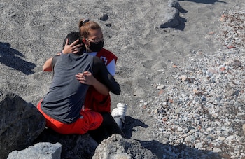 Luna Reyes, miembro de Cruz roja, abraza a joven subsahariano recién llegado a Ceuta (REUTERS/Jon Nazca)