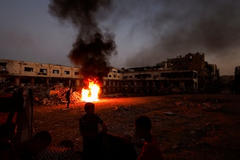 Palestinos se reúnen cerca de una hoguera que encendieron para mantener alejados a los mosquitos y otros insectos (REUTERS/Mohammed Salem)