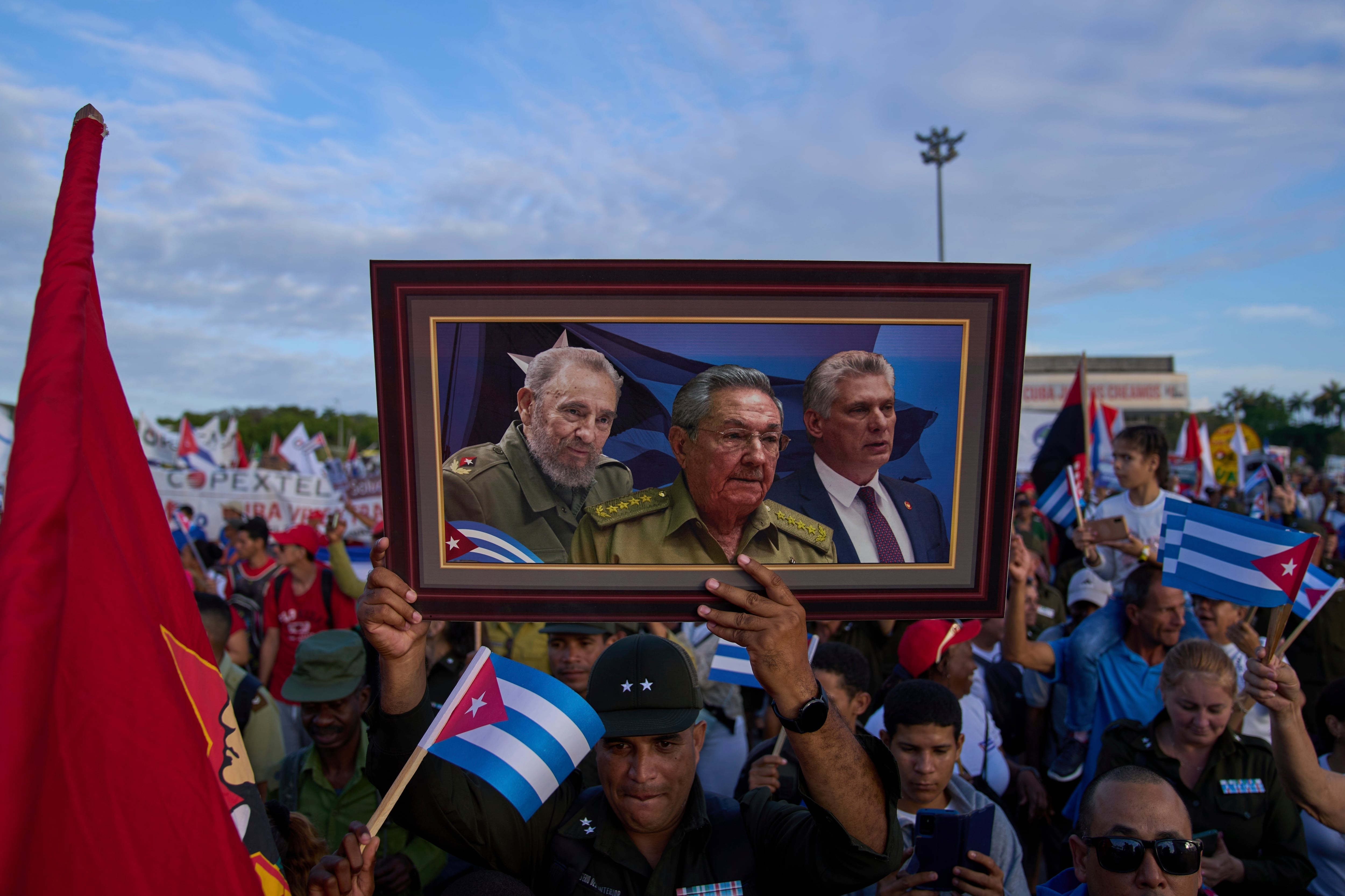 Una persona lleva en una marcha un cuadro con una imagen de Fidel Castro, Raúl Castro y Miguel Díaz-Canel, en la plaza de la Revolución en La Habana, Cuba (AP Foto/Ramon Espinosa, Archivo)