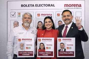 Tres personas, dos hombres y una mujer, sonríen frente a una boleta electoral grande. Sostienen reproducciones de segmentos de la boleta con sus fotos y nombres.