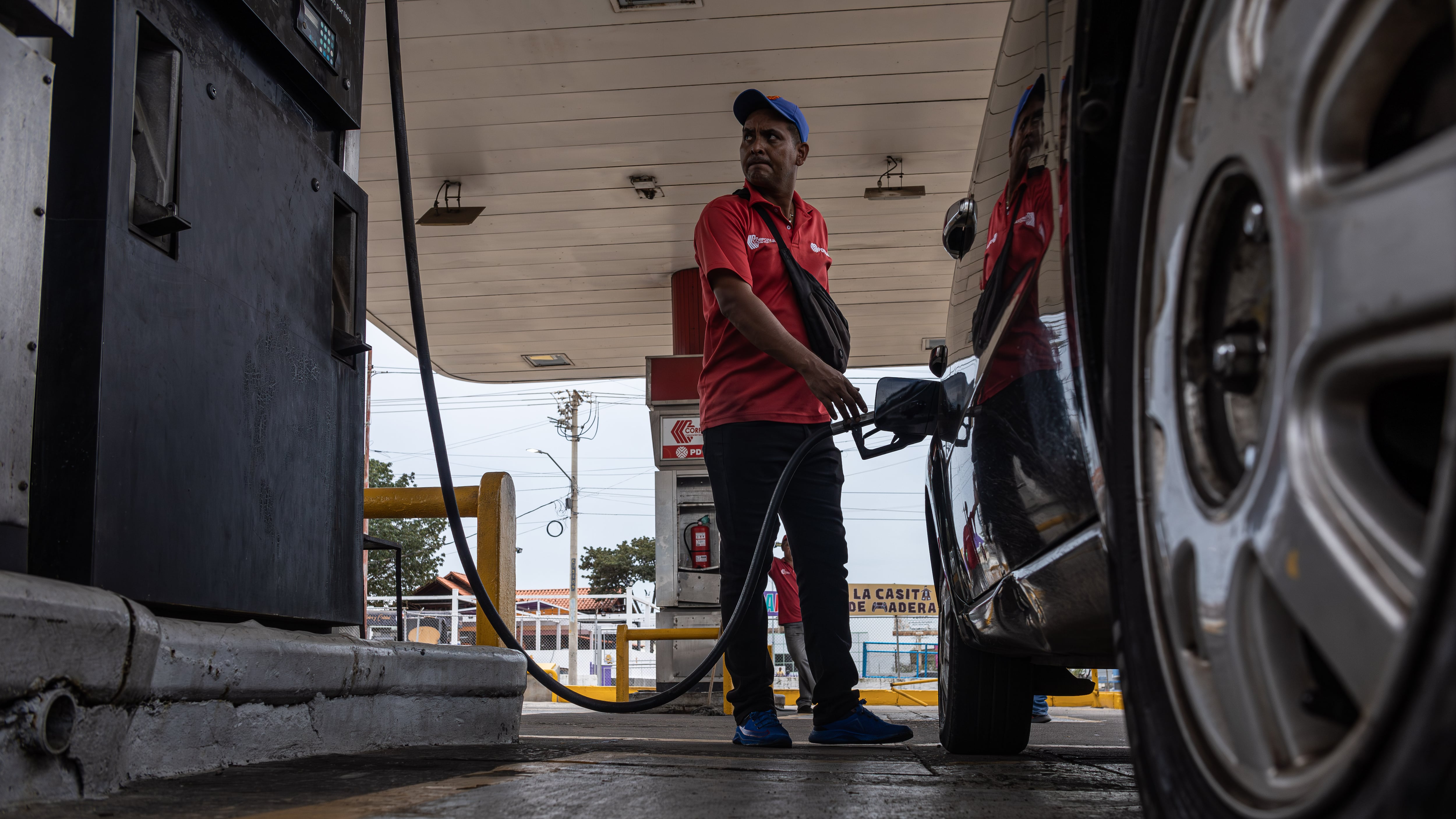 Un empleado de una estación de servicio despacha combustible (EFE/Henry Chirinos)