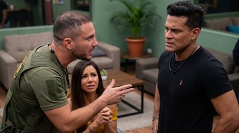Primer plano de Jenko, con camiseta verde, señalando a Christian Domínguez, de negro, en un ambiente interior. Paloma Fiuza, de amarillo, mira preocupada.