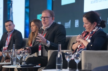 Panel de economistas en ExpoEFI: Emmanuel Álvarez Agis, con gafas y traje, habla gesticulando; Pilar Tavella, Andrés Borenstein, Marina Dal Poggetto y Santiago Bulat observan