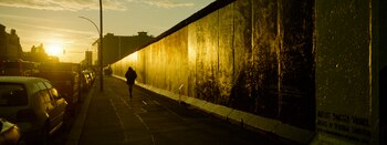 Una persona camina a lo largo de la llamada East Side Gallery, un lugar popular para el arte callejero sobre los restos del Muro de Berlín en Berlín, Alemania, el martes 22 de octubre de 2024