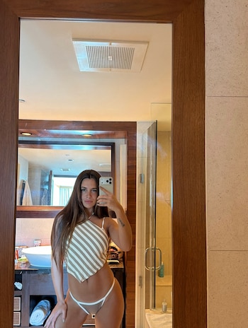 Una mujer se toma un autorretrato con su teléfono celular frente al espejo de un baño