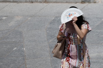 Una mujer se protege del sol con el abanico, este martes en Valencia. (Kai Forsterling/EFE)