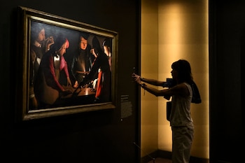 Una mujer fotografía el cuadro