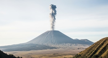 Un volcán en erupción moderada, solo vapor de agua saliendo del cráter