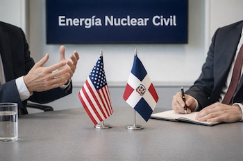 Manos de dos personas en trajes de negocios frente a una pantalla que muestra "Energía Nuclear Civil", con banderas de Estados Unidos y República Dominicana en una mesa de oficina.