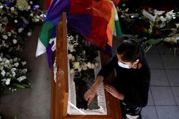 Una mujer toca el ataúd